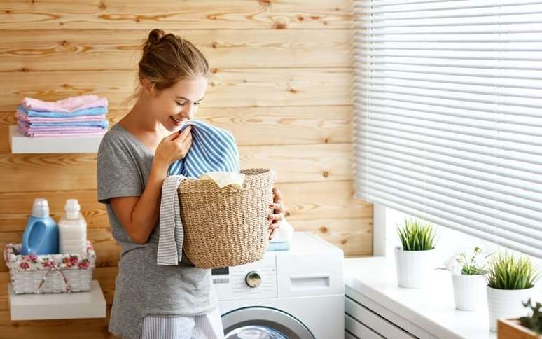 Mulher cheirando uma peça de roupa em uma lavanderia