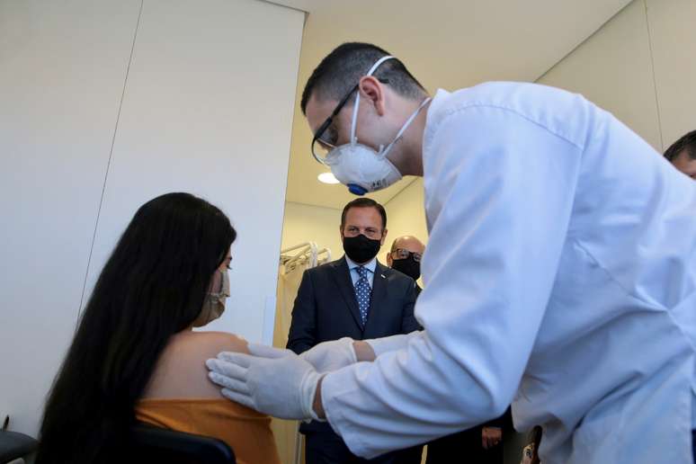 Voluntária recebe potencial vacina chinesa contra Covid-19, com o governador paulista, João Doria, ao fundo
21/07/2020
Governo do Estado de SP/Divulgação via REUTERS