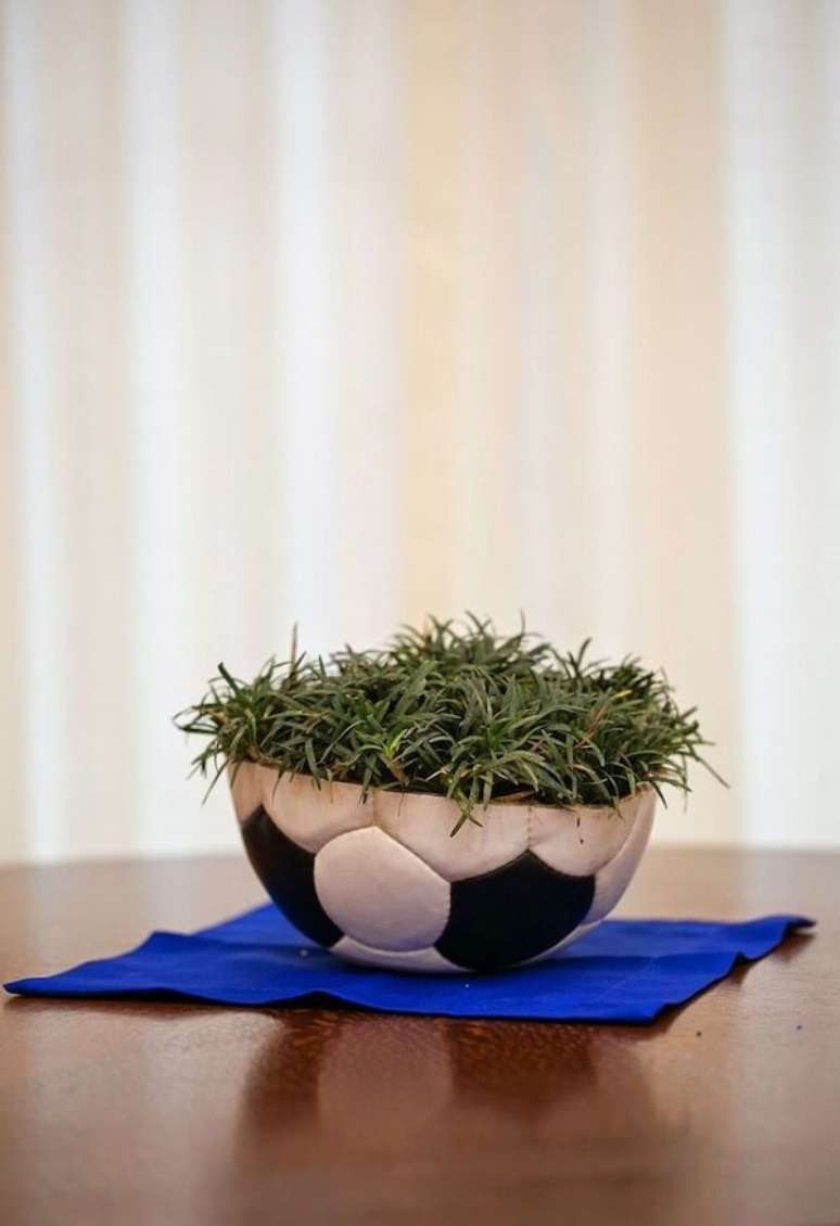 19. Decora&ccedil;&atilde;o de centro de mesa com bola e grama para festa de anivers&aacute;rio tema futebol. Fonte: Pinterest