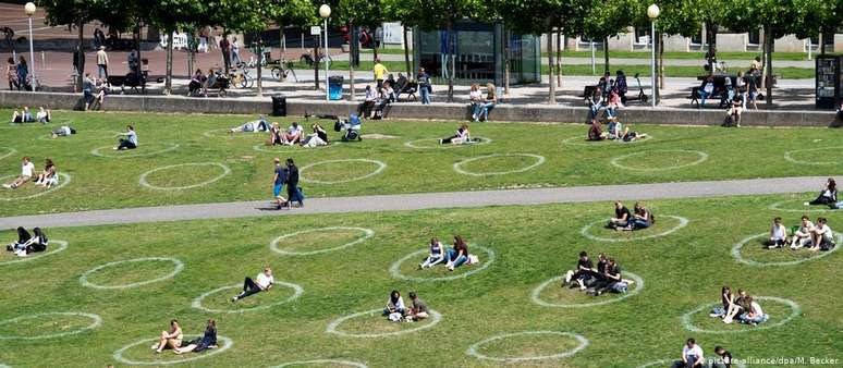 Em Düsseldorf, círculos marcados no gramado de um parque ajudam a manter o distanciamento entre as pessoas. 