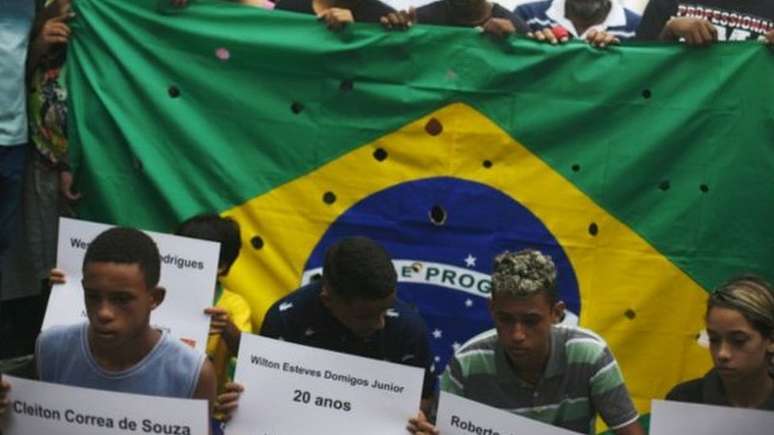 Bandeira do Brasil com buracos representa tiros de 111 balas disparadas pela pol&iacute;cia contra 5 jovens no Rio, em 2015