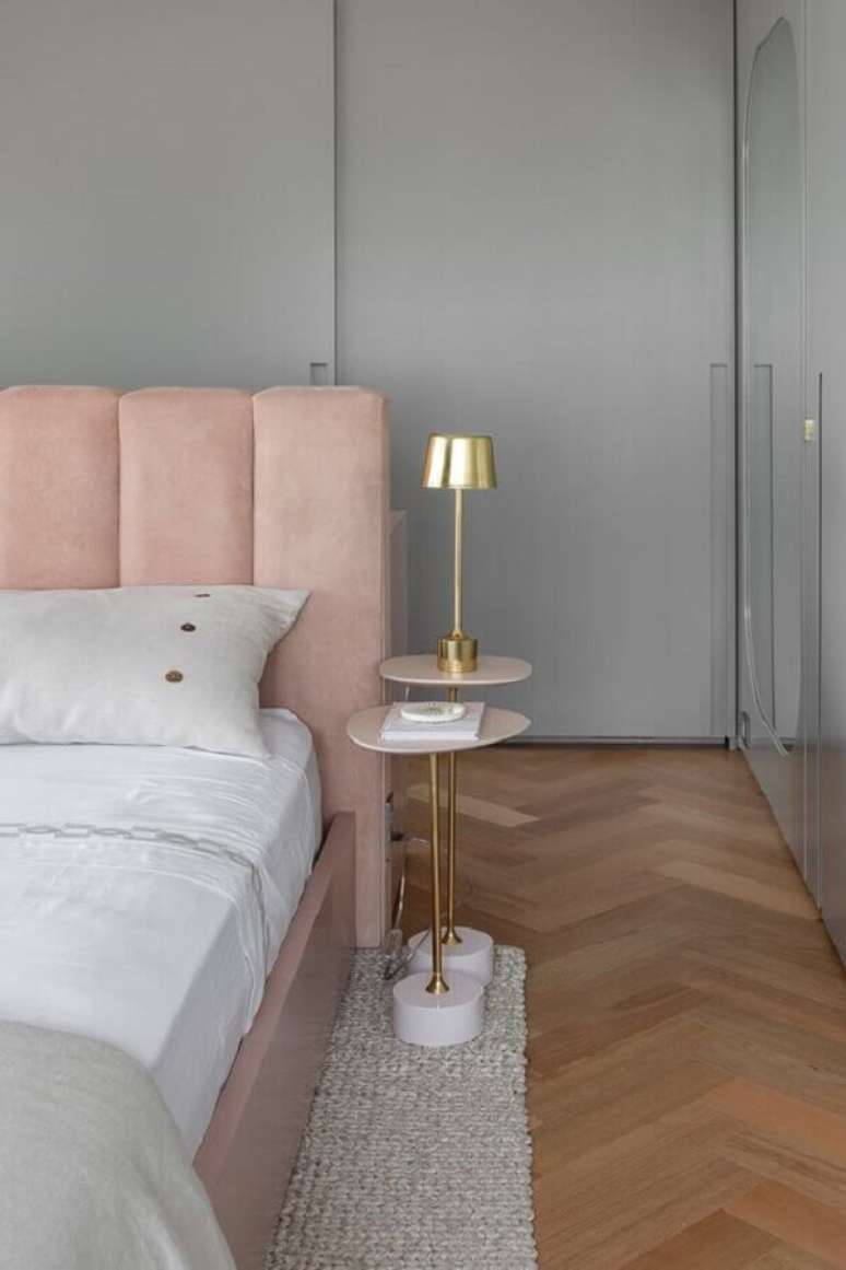 50. Decora&ccedil;&atilde;o moderna para quarto rosa e cinza com mesa de cabeceira pequena e abajur dourado &ndash; Foto: Lulu & Georgia