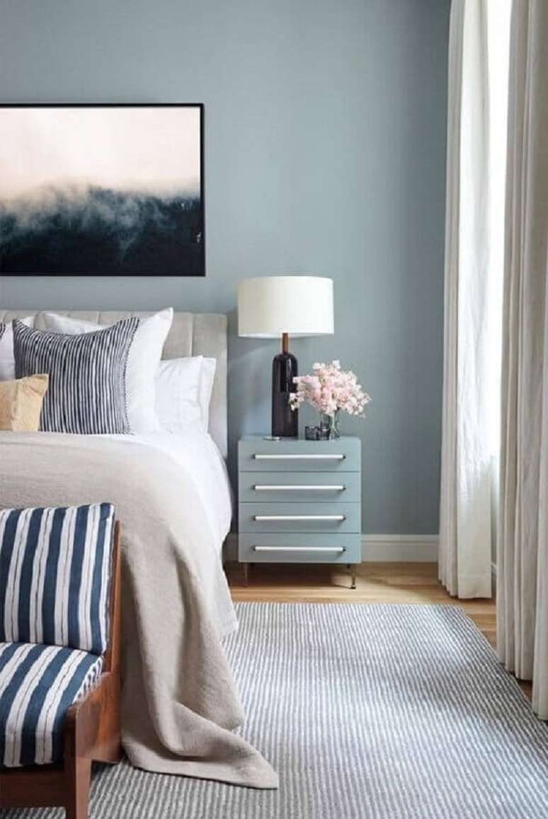 72. Quarto de casal azul decorado com mesa de cabeceira com gavetas e abajur com base preta &ndash; Foto: Apartment Therapy