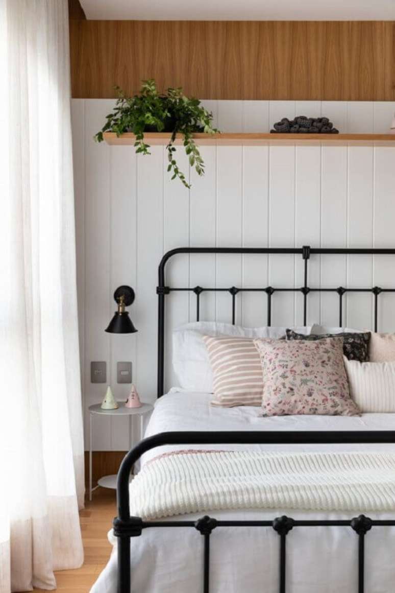11. Almofadas para cama de casal de ferro preta para decoração de quarto com abajur de parede – Foto: Apartment Therapy