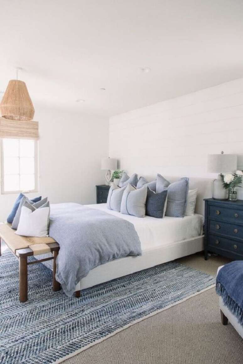 43. Decoração clean para quarto com cômoda azul e almofadas para cama de casal – Foto: Blanco Interiores