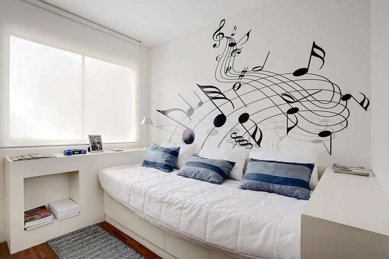 59. Quarto branco decorado com adesivos com notas musicais na parede e almofadas para cama de solteiro – Foto: Sesso & Dalanezi Arquitetura+Design