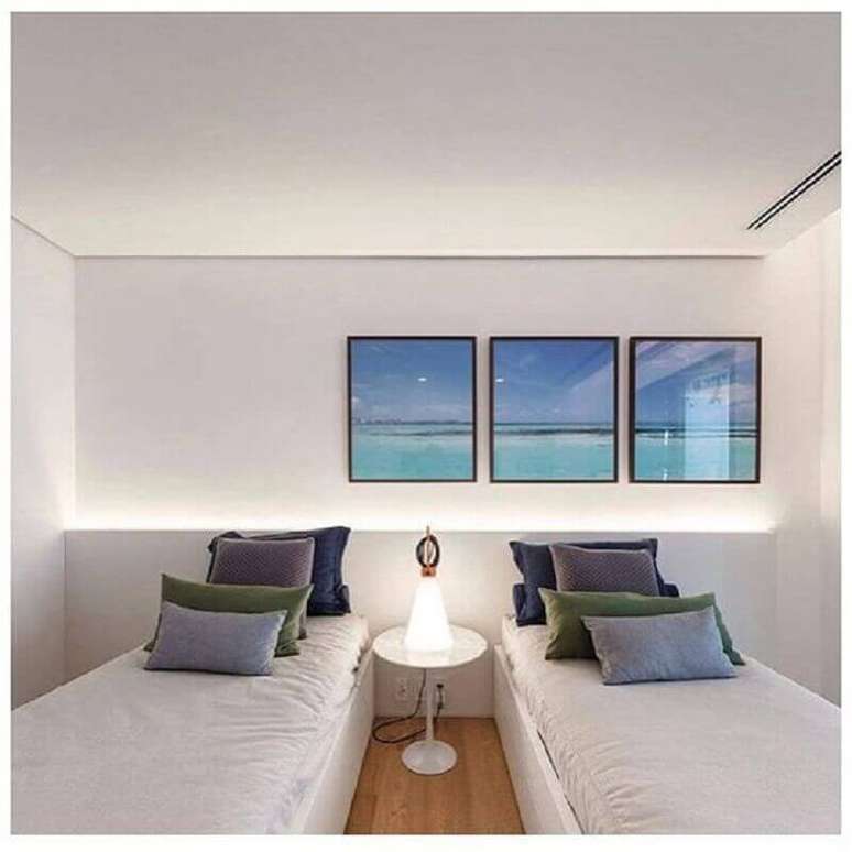 60. Decoração clean para quarto branco com trio de quadros e almofadas para camas de solteiro – Foto: Pinterest