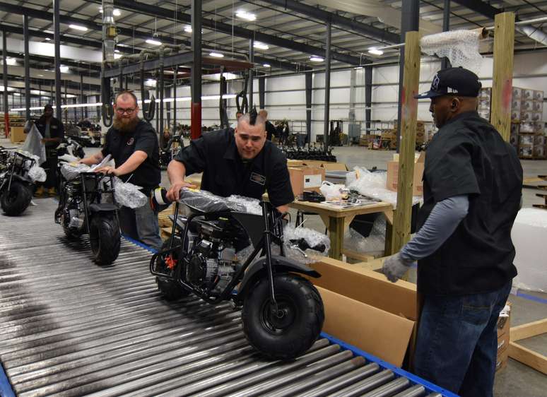 Jamison Spurlock (no centro) empurra uma minimoto para frente em uma linha de montagem na fabricante de motos e go-kart Monster Moto em Ruston, Louisiana, 25 de janeiro de 2017. REUTERS/Nick Carey