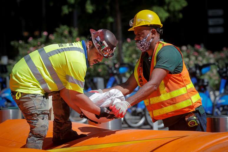 Trabalhadores empilham sacos de areia em torno de uma hidrelétrica enquanto se preparam para a tempestade tropical Isaias em Lower Manhattan em Nova York. 03/08/2020. REUTERS/Brendan McDermid. 
