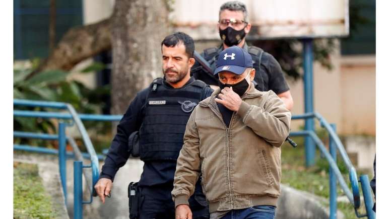 Queiroz conduzido à prisão em foto de junho; no mês seguinte, o ministro do STJ João Otávio de Noronha concedeu ao réu prisão domiciliar