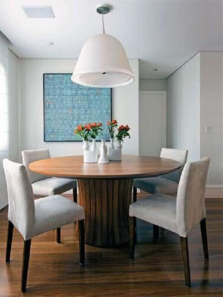 3. Sala de jantar decorada com lustre pendente grande e mesa de jantar redonda de madeira – Foto: Pinterest