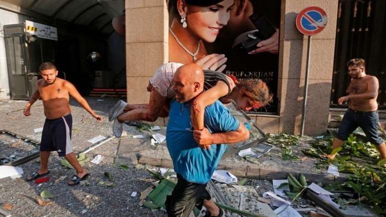 Homem retira mulher ferida de escombros em Beirute
