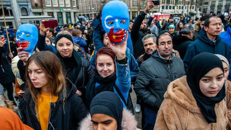 Manifestantes em Paris seguram cartazes pedindo o fim do "genocídio" dos uigures