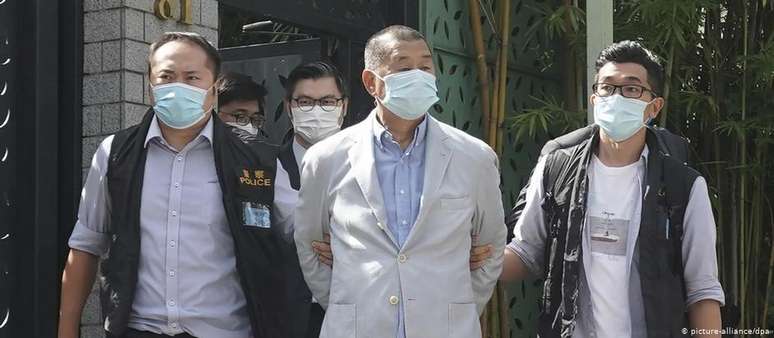 Jimmy Lai, empresário do vestuário que fundou grupo de mídia pró-democracia, é levado algemado por policiais