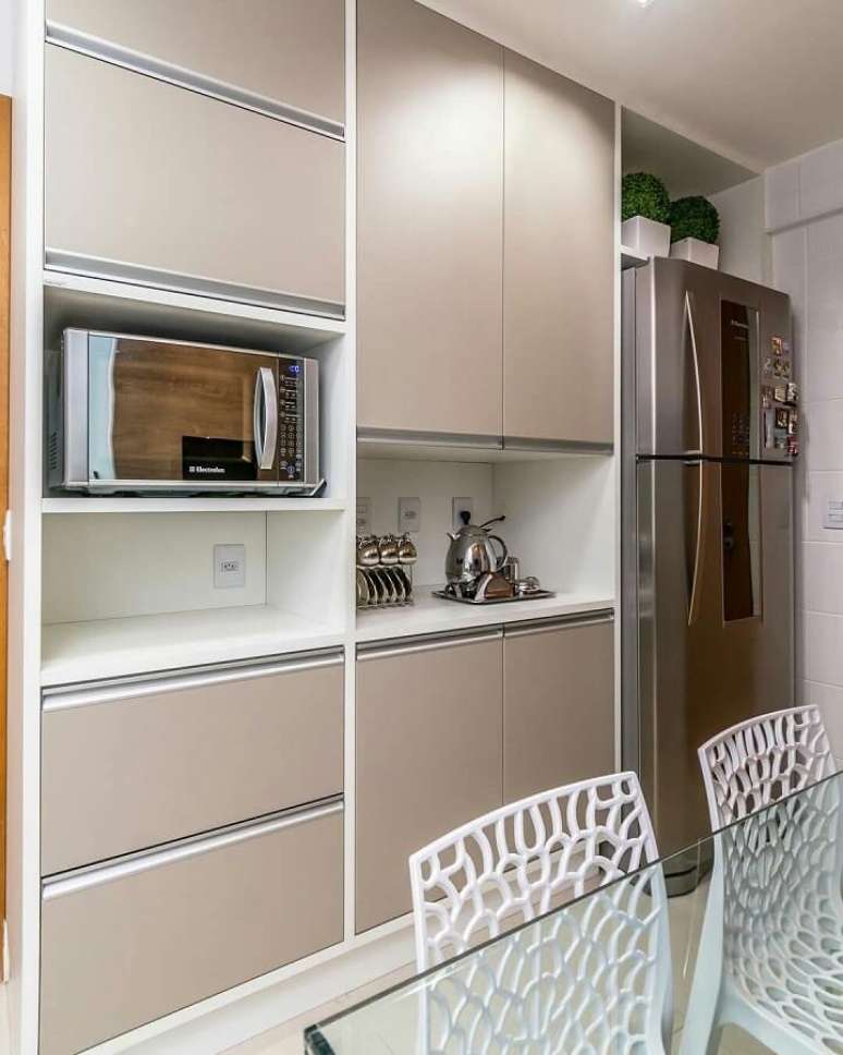 32. Armário de cozinha planejado com portas na cor nude e nichos brancos – Foto: Jeito de Casa