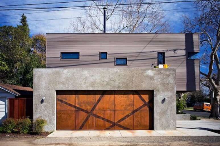 63. O portão de madeira se conecta perfeitamente com a fachada de concreto da casa. Fonte: Pinterest