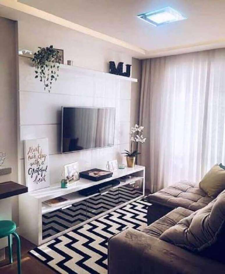 40. Decoração de sala de apartamento pequeno com tapete preto e branco e sofá retrátil – Foto: Pinterest