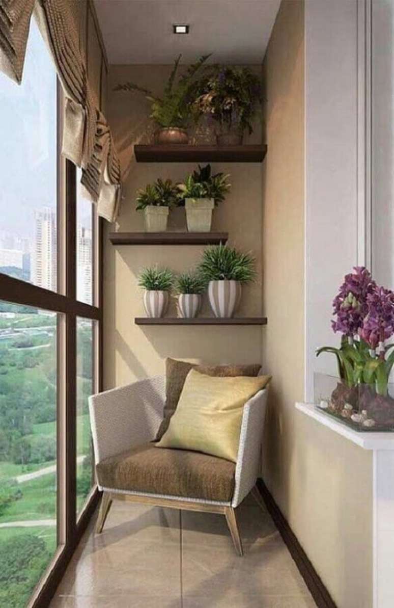 43. Ideia de decoração de varanda de apartamento pequeno com prateleiras para vasos de planta e poltrona confortável – Foto: We Heart It