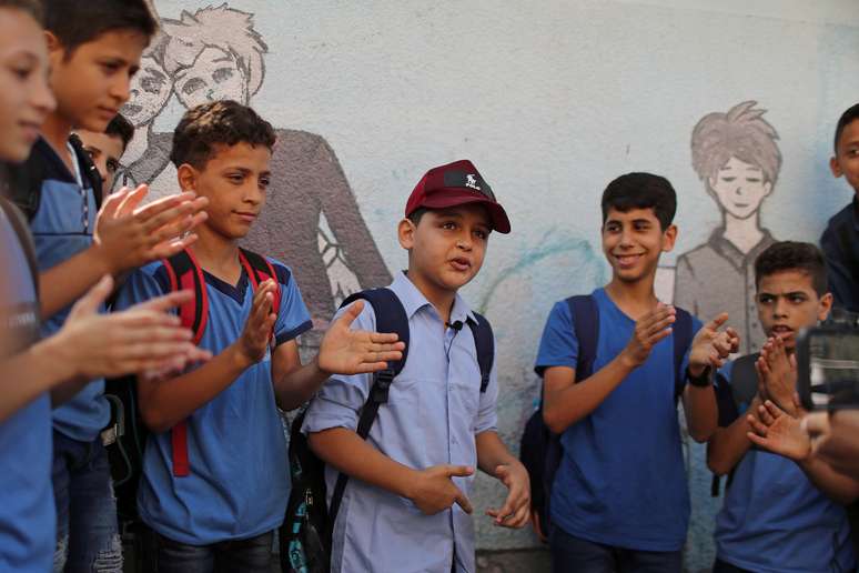 Abdel-Rahman Al-Shantti (ao centro, de boné), rapper de 11 anos de Gaza, é cercado por estudantes durante performance
16/08/2020 REUTERS/Mohammed Salem