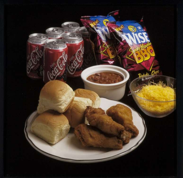 Uma refei&ccedil;&atilde;o com frango, p&atilde;ezinhos, feij&atilde;o, batatas fritas e refrigerante