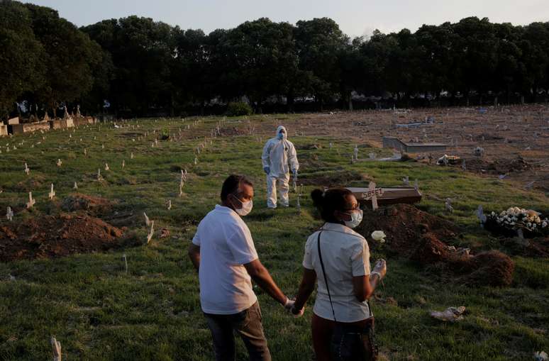 Casal em cemit&eacute;rio no Rio de Janeiro durante enterro de pessoa que morreu de causas desconhecidas durante a pandema de Covid-19
01/05/2020
REUTERS/Ian Cheibub