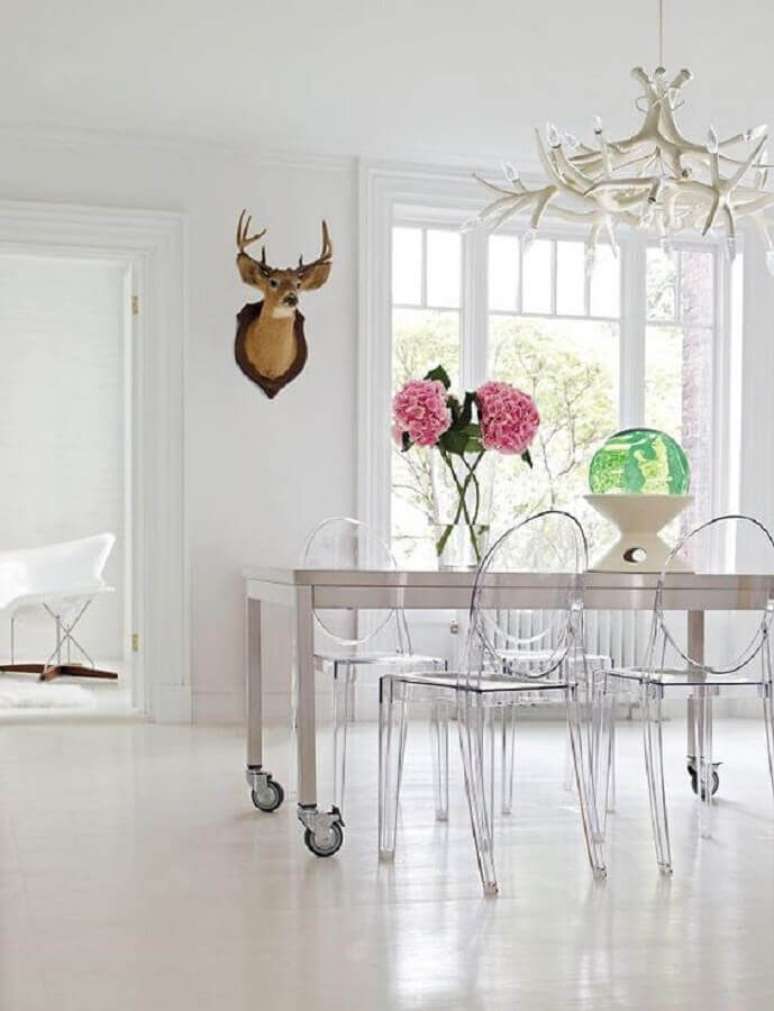 16. Decoração clean para sala de jantar com mesa de rodinhas e cadeira ghost transparente sem braço – Foto: Design Within Reach