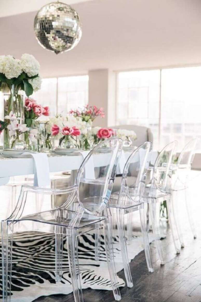 47. Cadeira transparente com braço para sala de jantar com mesa branca e tapete zebrado – Foto: Apartment Therapy