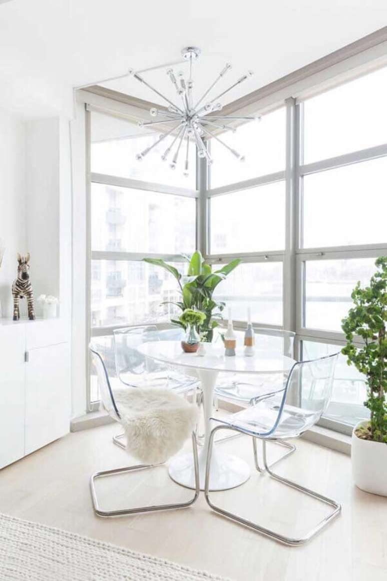 59. Sala de jantar toda branca decorada com mesa de vidro com cadeiras transparentes – Foto: Otimizi