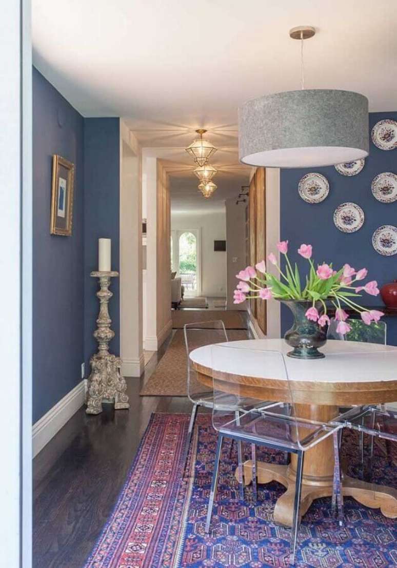 61. Decora&ccedil;&atilde;o de sala de jantar azul com cadeira transparente para mesa de madeira redonda &ndash; Foto: Constance Zahn