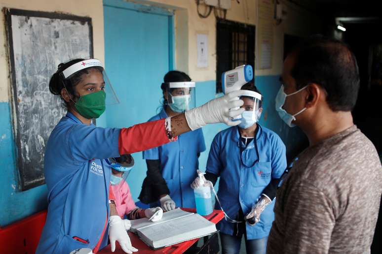 Funcionária de equipe médica mede temperatura de homem em escola em Mumbai, na Índia
10/08/2020
REUTERS/Francis Mascarenhas