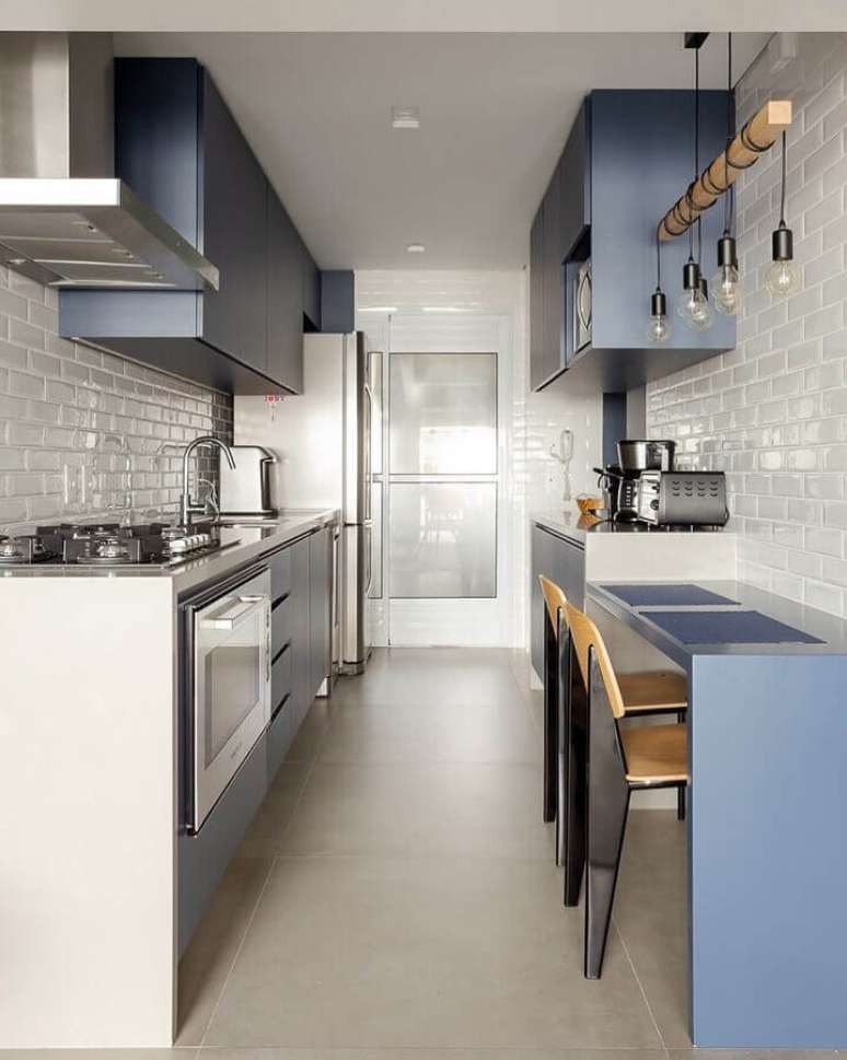 42. Ideias de bancada para cozinha pequena corredor com armários planejados azuis – Foto: MdeMulher