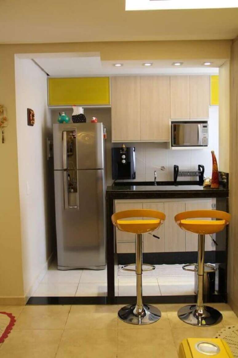 50. Bancada para cozinha americana pequena preta com banquetas amarelas &ndash; Foto: Dicas de Mulher