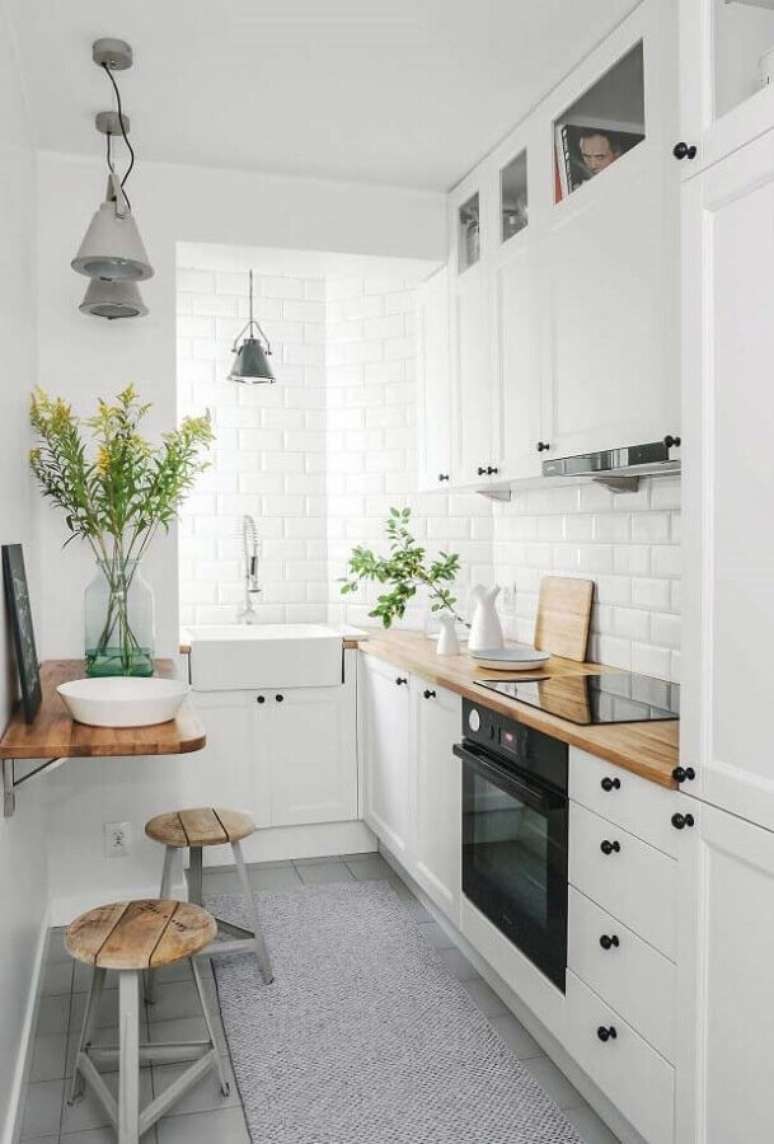 55. Decoração clean com armários brancos e bancada pequena para cozinha de madeira – Foto: Archilovers