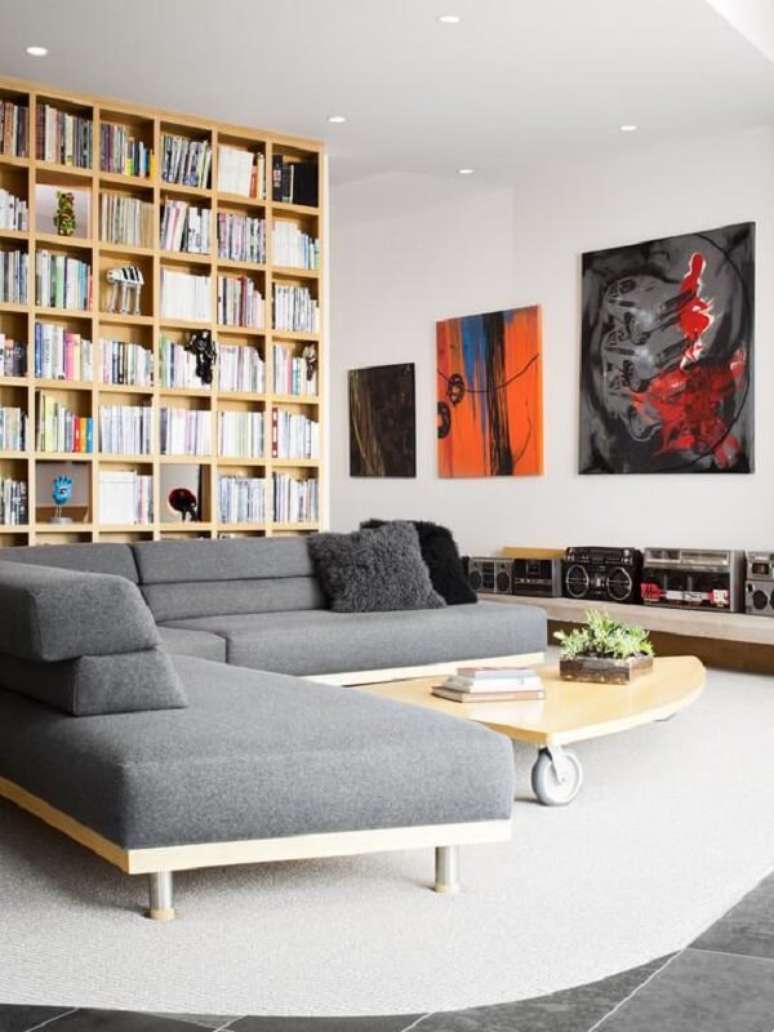 54. A base em madeira deixa o sofá de canto cinza mais moderno. Fonte: Pinterest