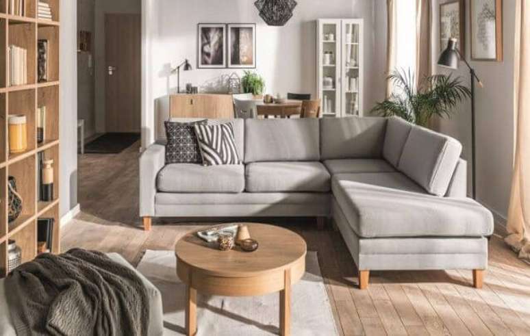 47. O acabamento em madeira trouxe ainda mais charme para esse sofá de canto pequeno cinza. Fonte: Panorama Móveis