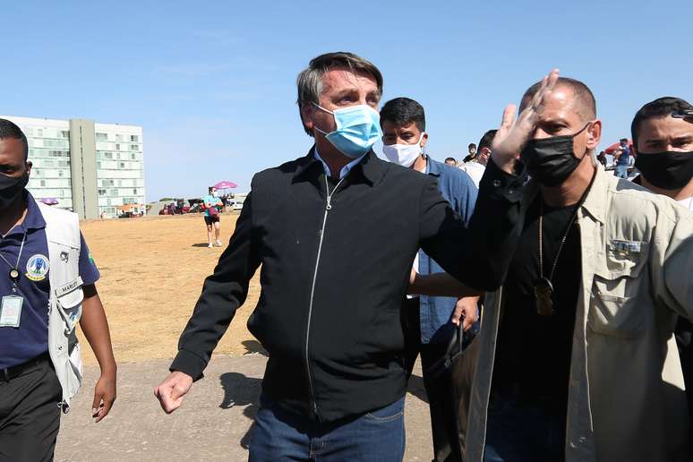 O presidente Jair Bolsonaro visita a Catedral de Brasília durante passeio, neste domingo (23). No local, ao ser perguntado por um repórter do jornal O Globo sobre o motivo dos depósitos feitos pelo ex-assessor Fabrício Queiroz à primeira-dama, Michelle Bolsonaro, o presidente respondeu: &#034;A vontade que eu tenho é de encher sua boca de porrada&#034;.