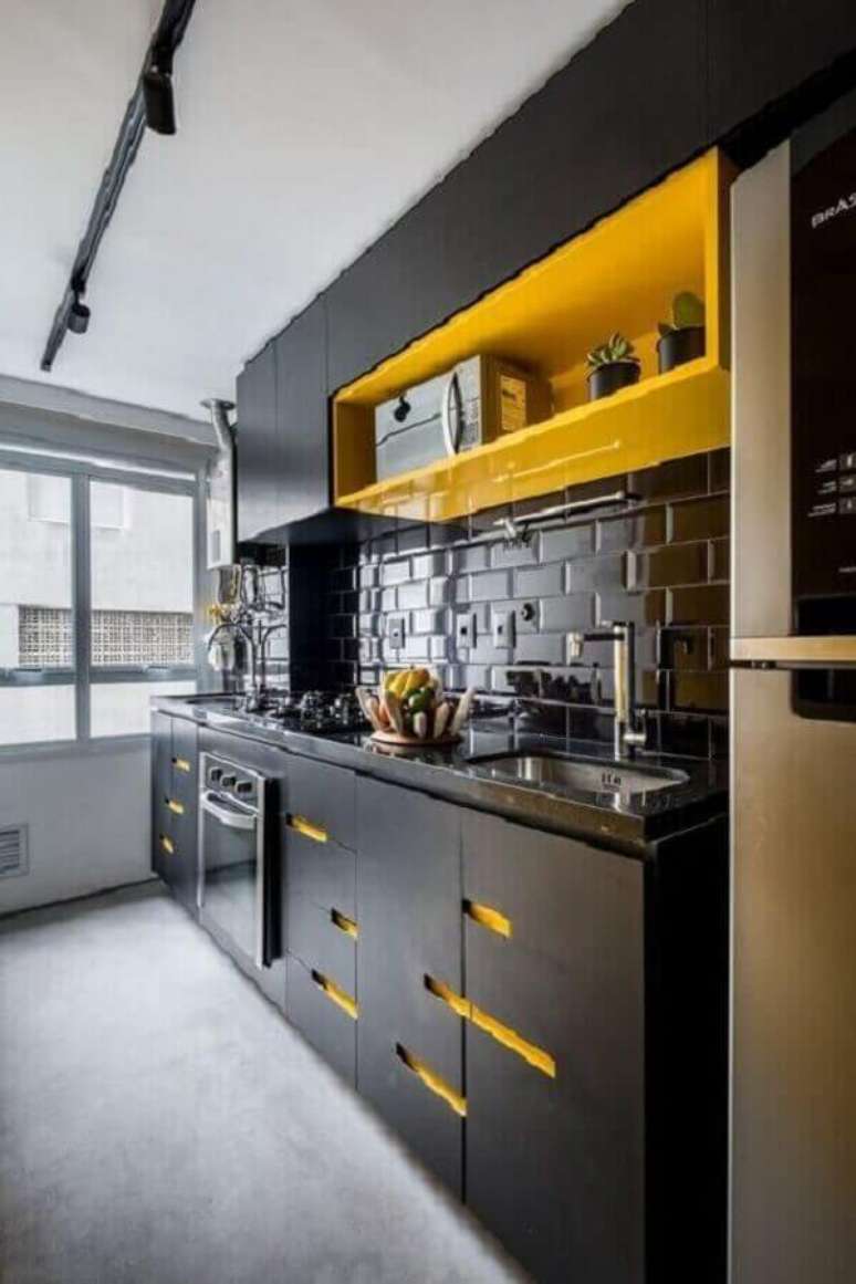 20. Os detalhes em amarelo deram um ar descontraído para o armário de cozinha pequeno planejado preto – Foto: Pinterest
