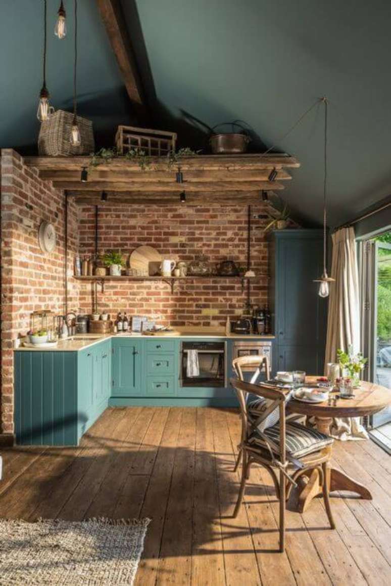 34. Tijolinho a vista na cozinha com armários azuis – Via: House of Turquoise