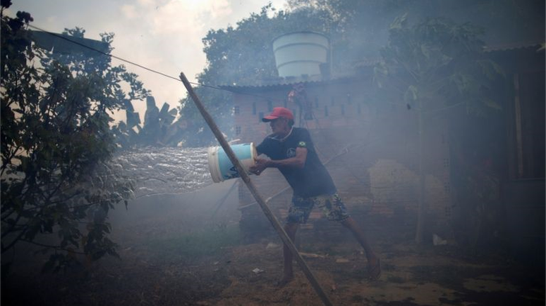 Rosalino de Oliveira tenta proteger casa do fogo, em Rondônia