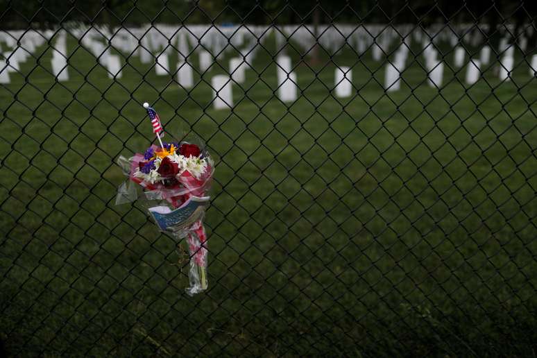 Flores são dispostas em grade de cemitério no Estado da Virginia, Estados Unidos. 27/05/2020. REUTERS/Carlos Barria. 

