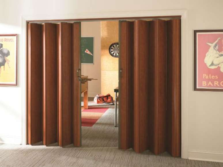 36. Porta de sanfona feita de madeira para sala de estar – Via: Accordion Doors