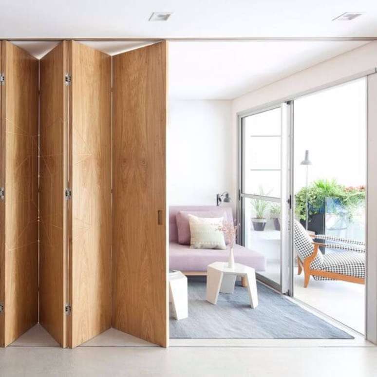 1. Porta sanfonada de madeira para sala de estar moderna – Via: Cote Maison