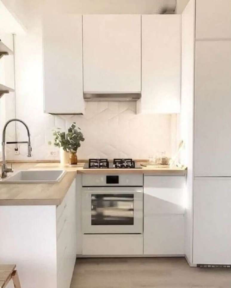 37. Decora&ccedil;&atilde;o de cozinha clara com revestimento 3D e arm&aacute;rio de cozinha pequeno branco com bancada de madeira &ndash; Foto: Houzz