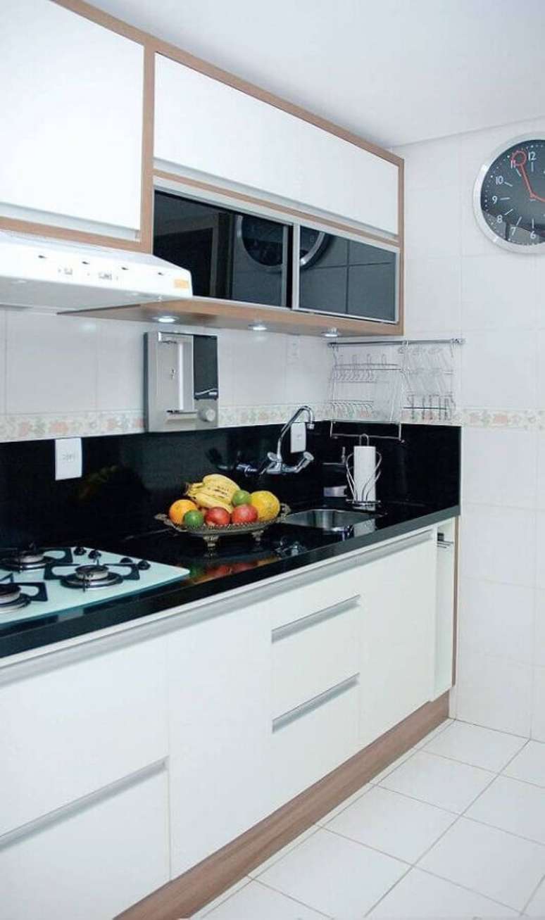 57. Bancada preta para arm&aacute;rio de cozinha branco pequeno planejado &ndash; Foto: Casa de Valentina