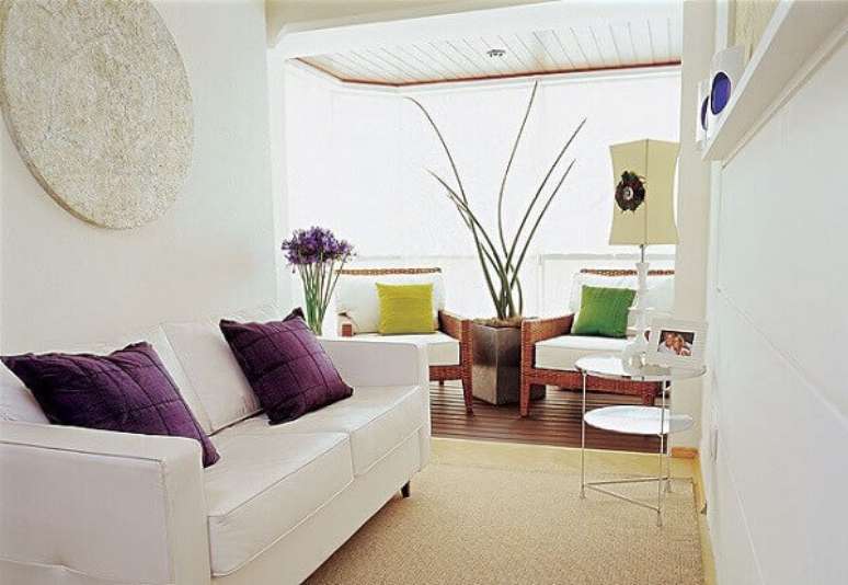 26- As plantas para sala tem a cor das flores que combinam com as almofadas e o vaso com a Lan&ccedil;a de S&atilde;o Jorge entre as poltronas. Fonte: Transforma sua casa