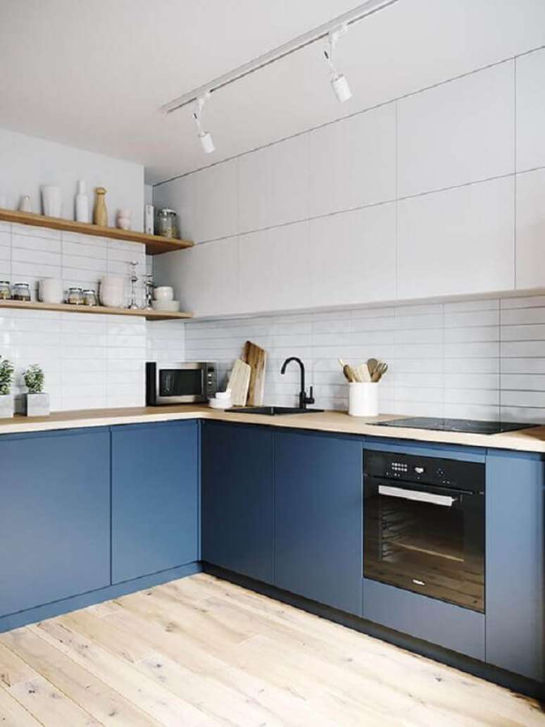 21. Decoração clean de cozinha sob medida de canto azul e branca com prateleiras e bancada de madeira – Foto: Arkpad