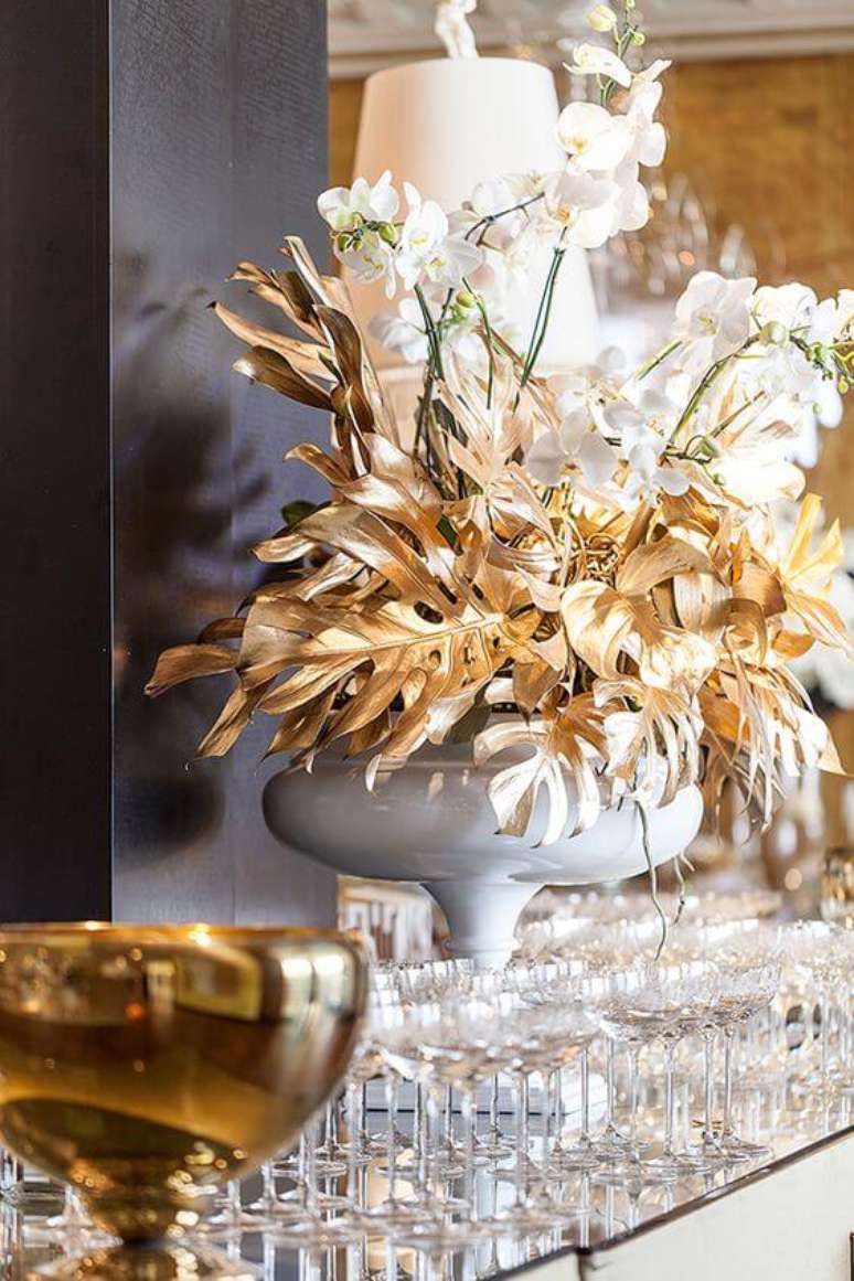 10. Decora&ccedil;&atilde;o com orqu&iacute;dea branca e planta costela de ad&atilde;o dourada &ndash; Via: Constance Zahn