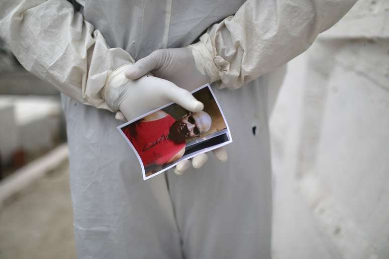 Coveiro segura foto de homem que morreu de coronavírus durante enterro em cemitério de Nova Iguaçu, no Rio de Janeiro
20/08/2020
REUTERS/Pilar Olivares