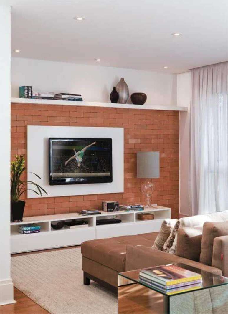 20. Sala decorada com suporte para TV na parede de tijolinho à vista – Foto: Viajando no Apê