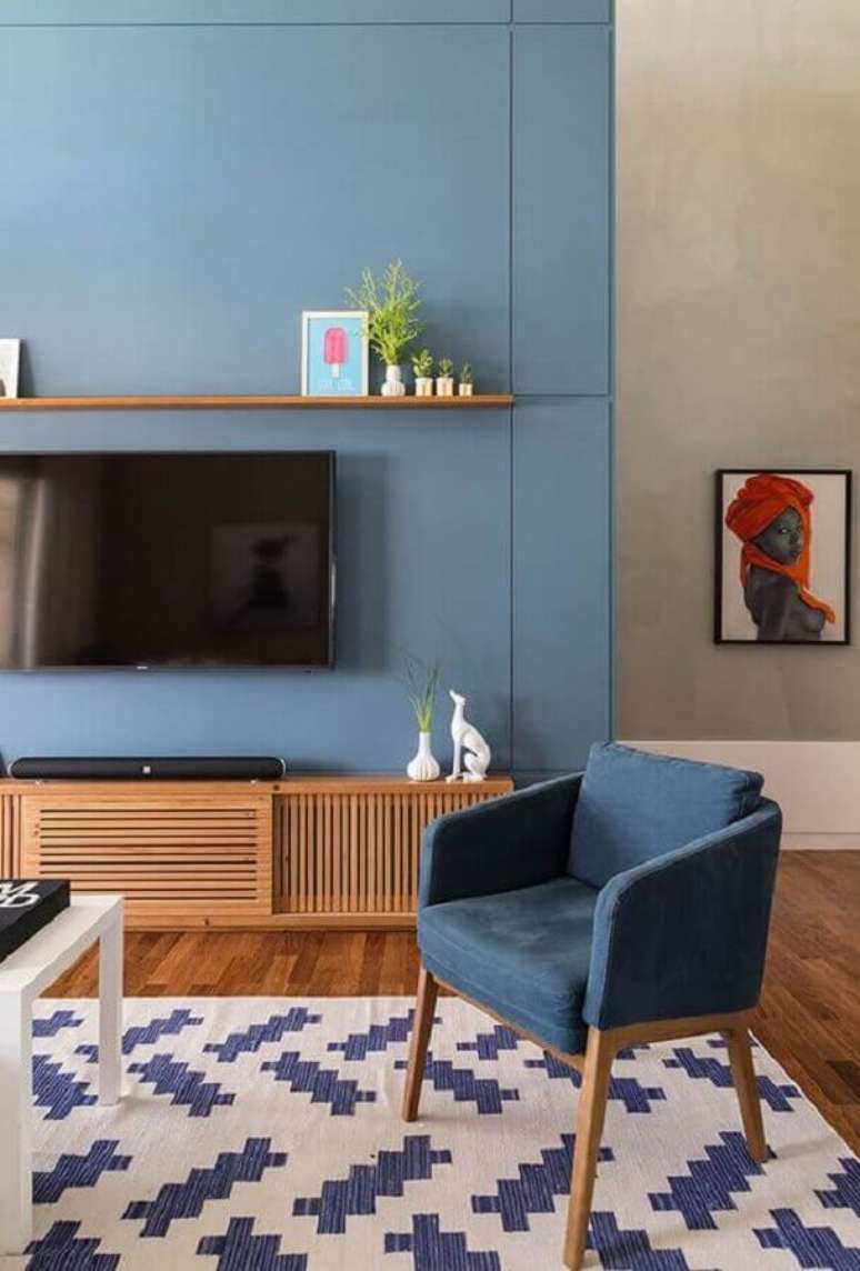 22. Decoração de sala com TV na parede azul com rack de madeira – Foto: Simplichique